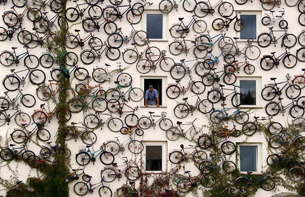 Những hình ảnh ấn tượng trong tuần ảnh 2 Co-owner Christian Petersen looks out of a window as he poses for the media at his bicycle shop in Altlandsberg, north-east of Berlin. The owners attached about 120 bicycles on the facade to advertise their shop