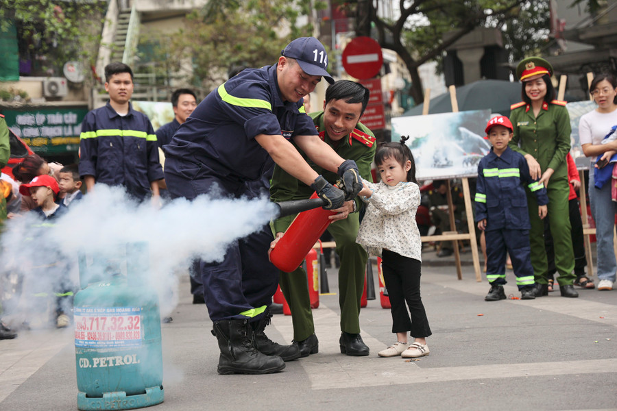 Các chiến sĩ PCCC&amp;CNCH Công an quận Hoàn Kiếm nhiệt tình hướng dẫn cách xử lý đám cháy cho các em học sinh.