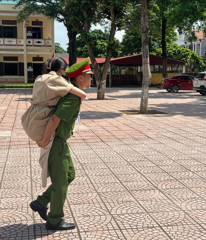 Trung uý Vũ Mạnh Cường - Cán bộ Đội điều tra tổng hợp, Công an huyện Thanh Thuỷ cõng thí sinh bị khuyết tật vào điểm thi trường THPT Trung Nghĩa, Phú Thọ. (Ảnh: Công an tỉnh Phú Thọ).