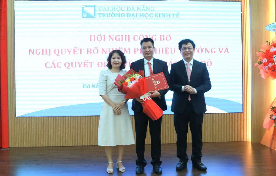 PGS.TS Lê Văn Huy – Hiệu trưởng (bìa phải ảnh) và PGS.TS. Võ Thị Thúy Anh – Chủ tịch Hội đồng Trường, trao Nghị quyết và tặng hoa chúc mừng tân Phó Hiệu trưởng PGS.TS Đoàn Ngọc Phi Anh. Ảnh: Ban Truyền thông DUE.