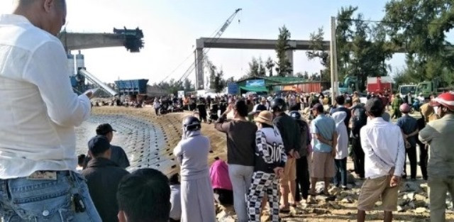 Người dân và lực lượng chức năng tập trung ở khu vực xảy ra tai nạn ngóng chờ đội cứu hộ đưa thi thể nạn nhân lên bờ. (Ảnh: VT)