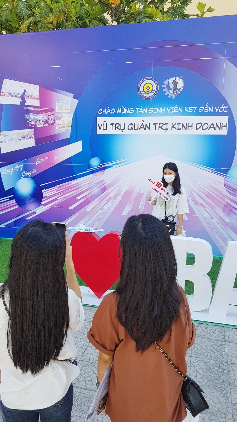 Các tân nữ SV K57 chụp ảnh check-in ở gian hàng khoa Quản trị Kinh doanh.
