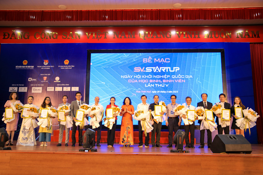 Thứ trưởng Bộ GD&ĐT Ngô Thị Minh tặng hoa và thư cảm ơn cho Ban giám khảo chấm điểm các dự án của cuộc thi.