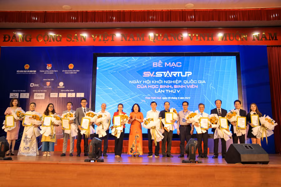 Thứ trưởng Bộ GD&ĐT Ngô Thị Minh tặng hoa và thư cảm ơn cho Ban giám khảo chấm điểm các dự án của cuộc thi.