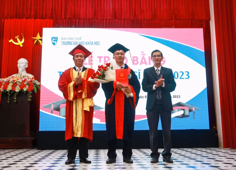 Đại diện lãnh đạo Trường trao bằng cho các tân thạc sĩ.