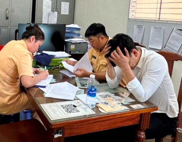 Tài xế Lê Quang Huy (áo trắng) làm việc tại Đội CSGT TP Huế. (Ảnh: Đại Dương).