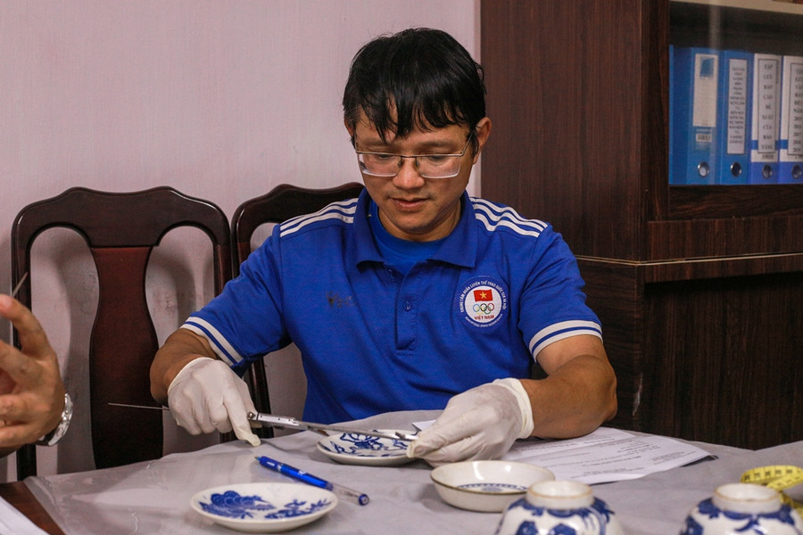 Đại diện Bảo tàng Cổ vật Cung đình Huế tiến hành đo đạc kích thước hiện vật và ghi vào biên bản tiếp nhận.