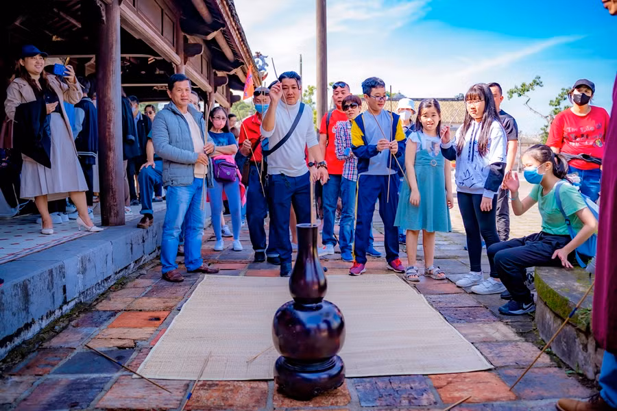 Trò Đầu Hồ - ném các thanh tre vào trong một bình gỗ có miệng nhỏ.