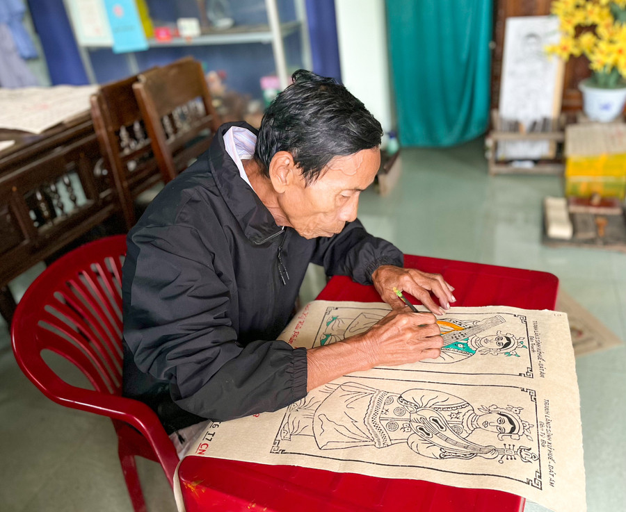 Nghệ nhân Kỳ Hữu Phước với 67 năm trong nghề làm tranh làng Sình đang tô màu cho bức tranh.