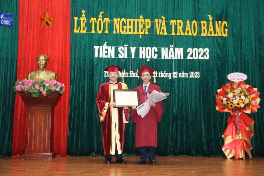 GS.TS. Nguyễn Vũ Quốc Huy - Hiệu trưởng Trường ĐH Y - Dược, ĐH Huế (trái) trao bằng Tiến sĩ Y học cho các nghiên cứu sinh.