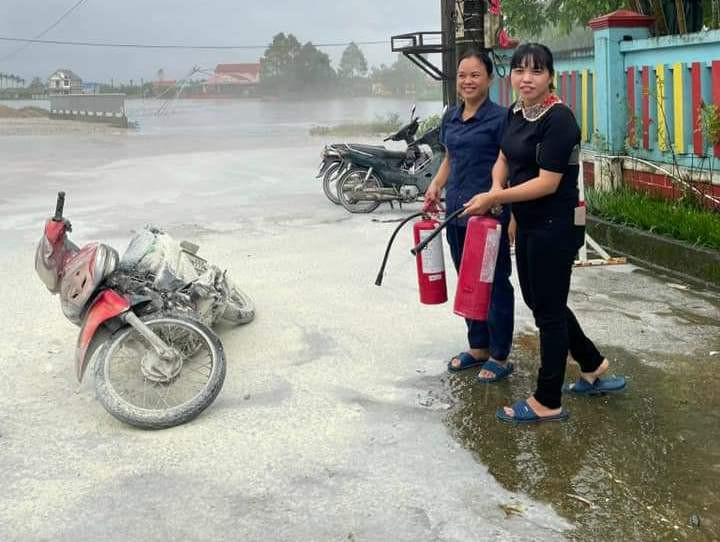 Các cô giáo đang dạy học trong trường lao ra và dùng bình chữa cháy dập tắt đám cháy trên xe máy. (Ảnh: ANTT huyện Phong Điền) Các cô giáo đang dạy học trong trường lao ra và dùng bình chữa cháy dập tắt đám cháy trên xe máy. (Ảnh: ANTT huyện Phong Điền)
