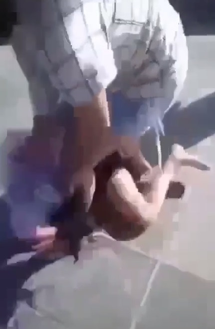 Một nữ sinh dùng chân và tay đánh tới tấp vào phần đầu, bụng của V. (Ảnh cắt từ clip do gia đình cung cấp)