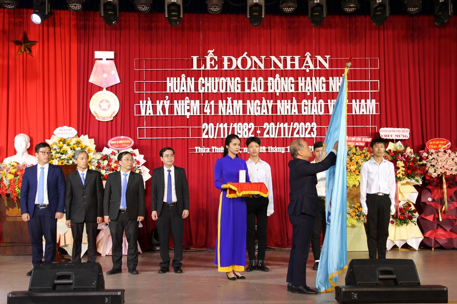 Ông Phan Ngọc Thọ, Phó Bí thư Thường trực Tỉnh ủy Thừa Thiên - Huế gắn Huân chương Lao động hạng Nhì lên cờ truyền thống Trường ĐH Sư phạm, ĐH Huế.