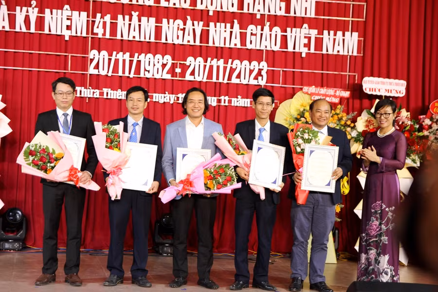 TS Tạ Thị Thu Hiền, Giám đốc Trung tâm Kiểm định chất lượng giáo dục - ĐH Quốc gia Hà Nội (phải) trao chứng nhận đạt chuẩn cho các trưởng khoa nhà trường.