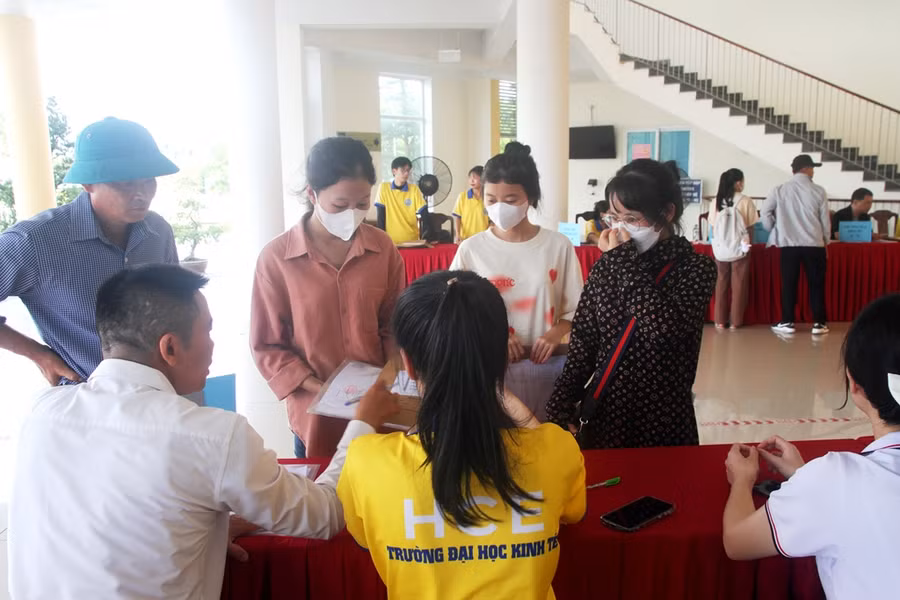 Các phụ huynh đi cùng thí sinh trúng tuyển làm thủ tục nhập học vào Trường ĐH Kinh tế, ĐH Huế (Ảnh: Đại Dương).