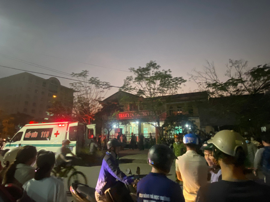 Xe cứu thương và rất đông người dân đứng ngoài sân bóng mini theo dõi.