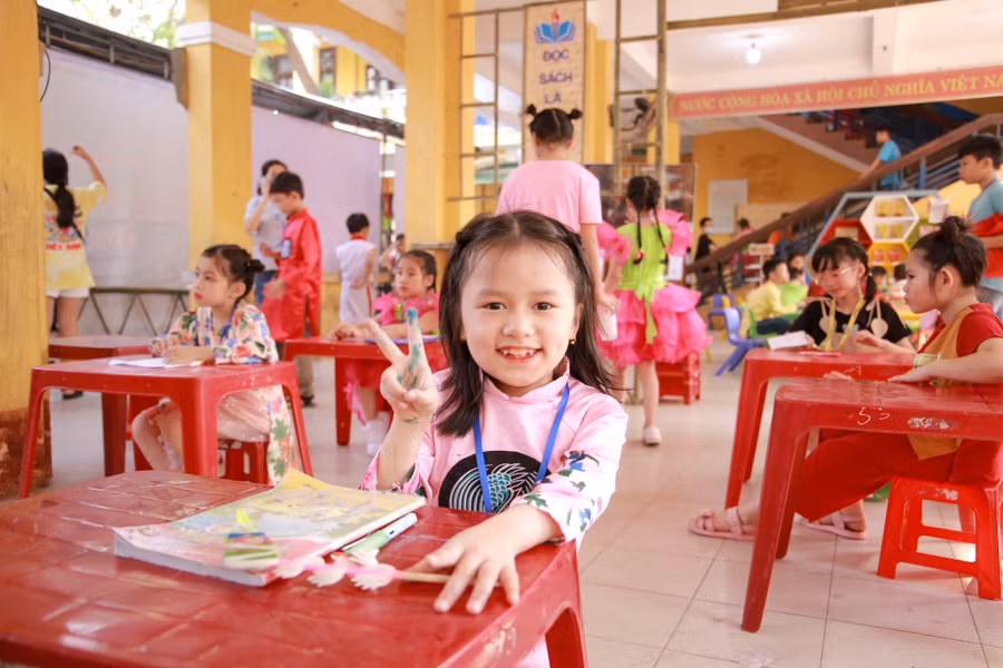 Một học sinh với nụ cười tươi tắn chuẩn bị tham gia cuộc thi Giao lưu “Biệt tài chữ đẹp Cao Bá Quát”.