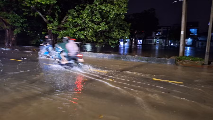 Người dân cố lội qua đoạn nước lũ để về nhà trong đêm.