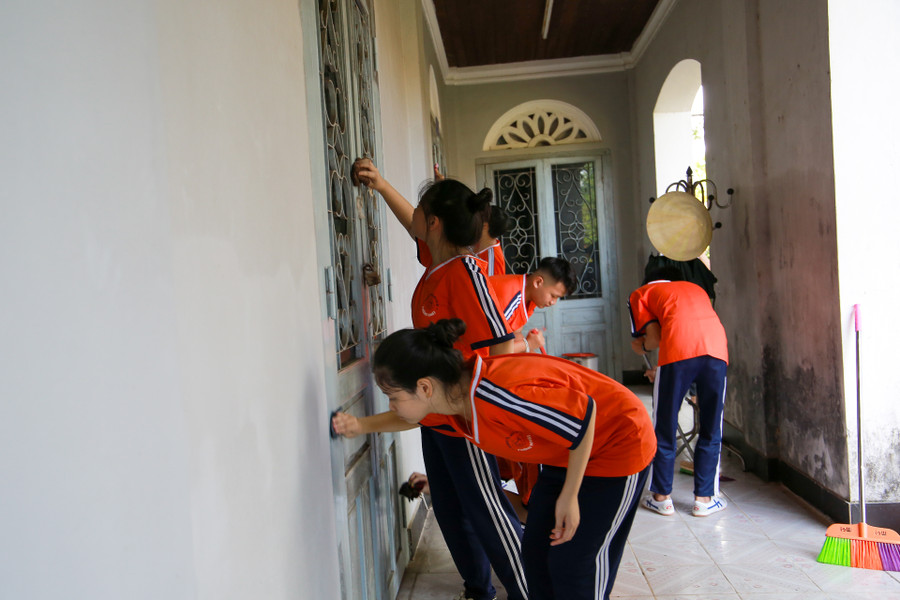Học sinh quét dọn, lau chùi hành lang và hệ thống cửa của Di Luân Đường.