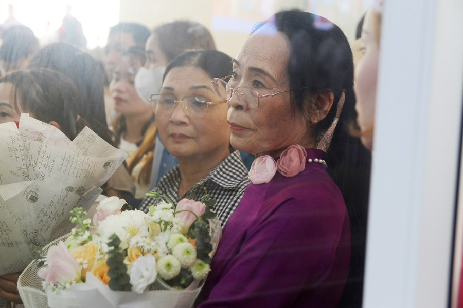 Một phụ huynh đứng ngoài hội trường dõi vào trong nhìn con.