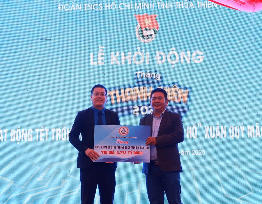 Ông Phạm Minh Tuấn - Phó Chủ tịch Hiệp hội Bất động sản Thừa Thiên - Huế (phải) trao tặng bảng tượng trưng hỗ trợ 1.980 chiếc xe đạp cho 132 trường THCS trên địa bàn tỉnh trị giá 2,772 tỷ đồng cho ông Nguyễn Thanh Hoài – Bí thư Tỉnh đoàn Thừa Thiên – Huế (trái).