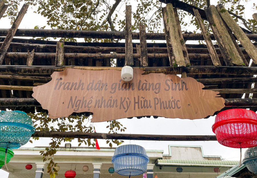 Treo bảng tranh làng Sình trước cổng để du khách vào tham quan.