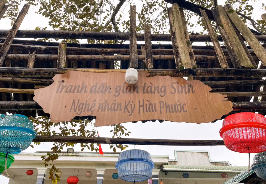 Treo bảng tranh làng Sình trước cổng để du khách vào tham quan.