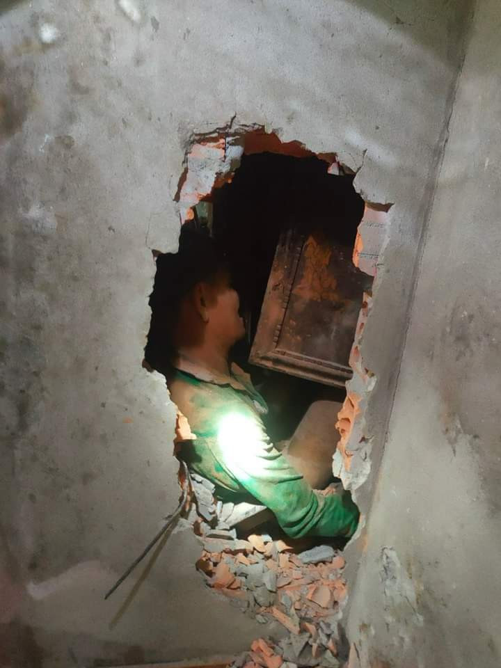 Công an khoan tường đưa người chồng bị mắc kẹt ra ngoài.