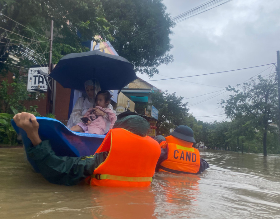 Thai phụ Trần Thị Ý và con nhỏ được Công an phường An Cựu đưa ghe đến nơi an toàn.