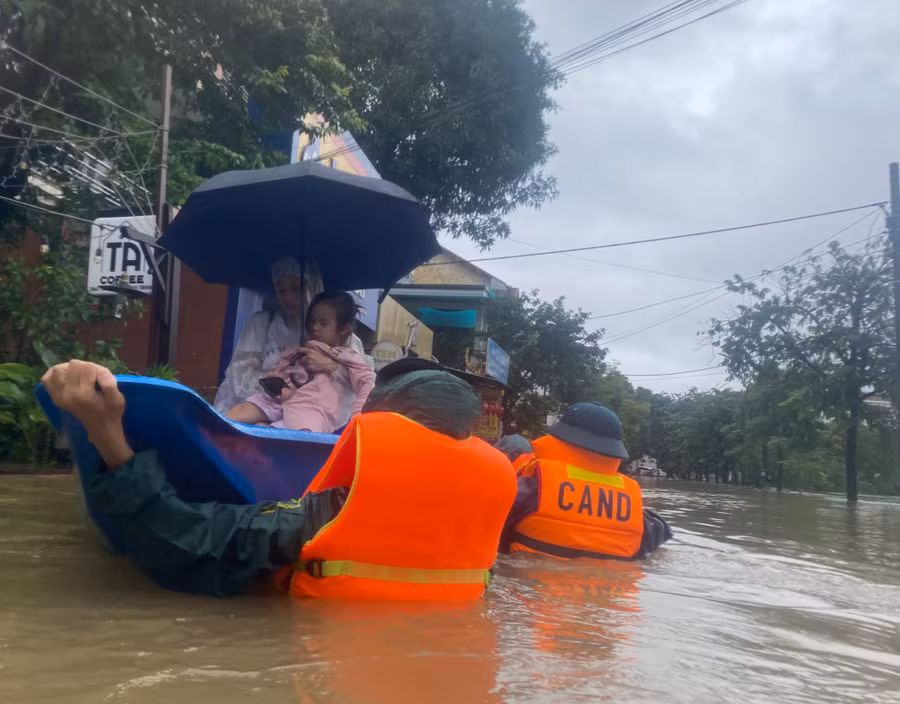 Thai phụ Trần Thị Ý và con nhỏ được Công an phường An Cựu đưa ghe đến nơi an toàn.