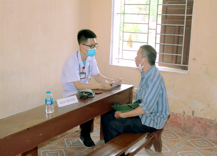 Các bác sĩ của Đoàn thanh niên Đại học Y Hà Nội tư vấn, khám chữa bệnh cho người dân thuộc gia đình chính sách tại địa phương.