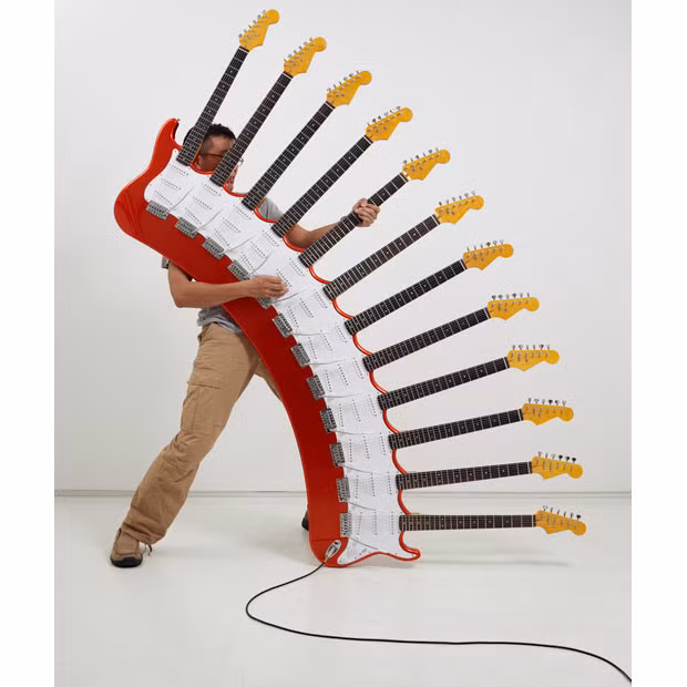 A man demonstrates a 12-necked guitar, one of many wacky designs created by artist Yoshihiko Satoh. The bizarre guitars take up to six months to build and have sold for as much as 60,000 pounds.