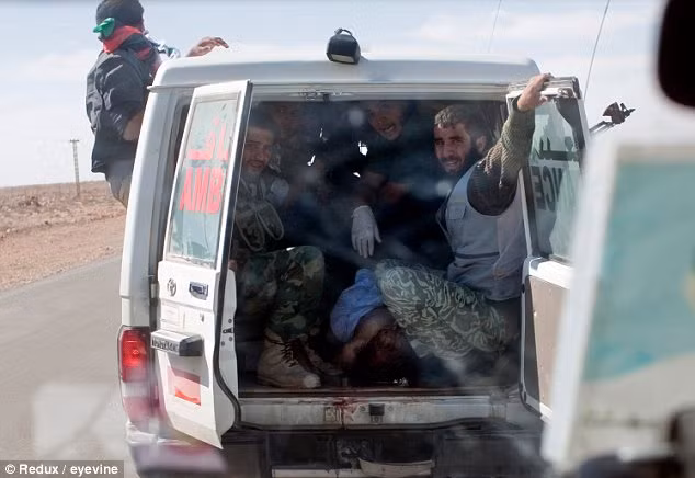 An ambulance, containing happy rebel fighters, carries Gaddafi’s body after he was executed Read more: http://www.dailymail.co.uk/news/article-2051361/Gaddafi-dead-Dictator-begged-life-summarily-executed.html#ixzz1bNfAbAyu