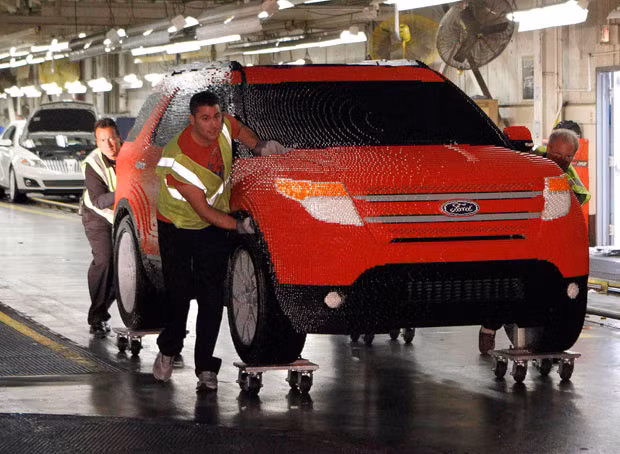 Workers from Ford’s Chicago Assembly Plant push a full-size Ford Explorer made with more than 380,000 Lego blocks, at Ford’s Chicago Assembly Plant