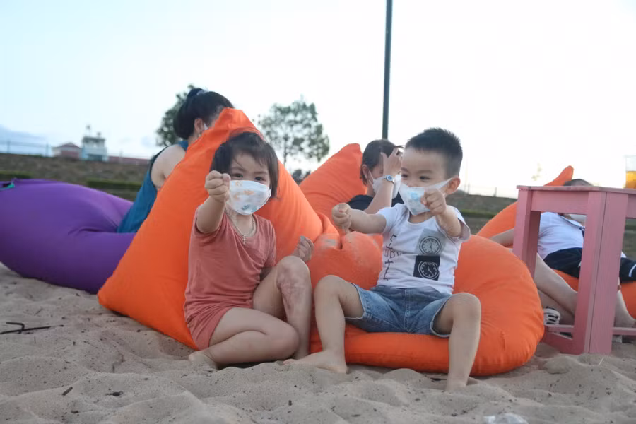 Những đứa trẻ thích thú, nô đùa nghịch cát với tiếng cười giòn tan.