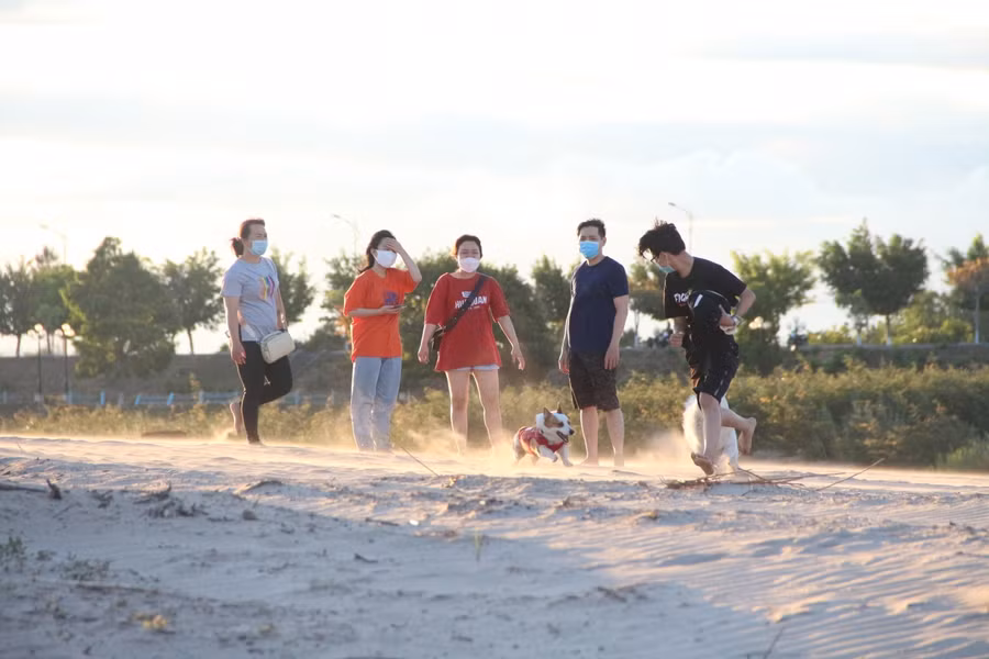 Khi nắng dần tắt, từng tốp người dạo chơi trên bãi cát để thư giãn.