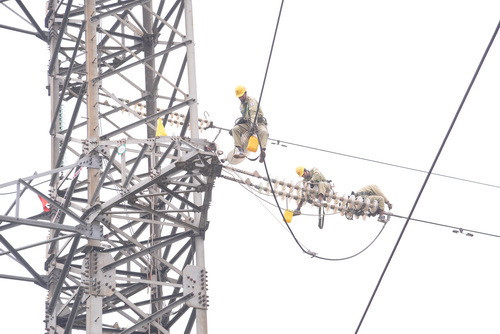 Những ngày giáp Tết, người thợ truyền tải điện vẫn miệt mài làm việc trên đường dây. Ảnh: VGP