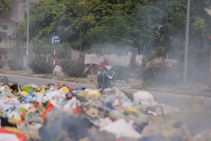 Đến buổi chiều, nhiều người còn mang đốt tại 1 góc bãi rác tạm, khói và mùi rác làm cho những người sinh sống tại khu vực cũng như người đi đường rất khó chịu