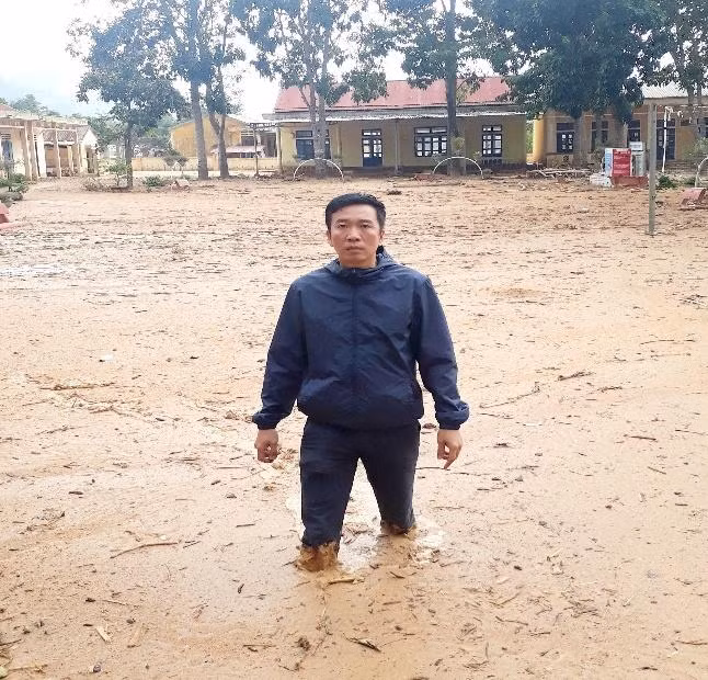 Thầy giáo Nguyễn Văn Tý giữa sân trường đầy rẫy bùn đất sau trận lũ quét năm 2020.