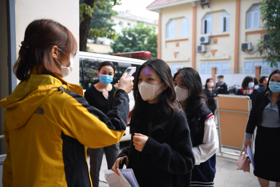 Toàn bộ học sinh đến tiêm sẽ đều được đo thân nhiệt, rửa tay sắt khẩn trước khi vào làm thủ tục tiêm vắc xin.