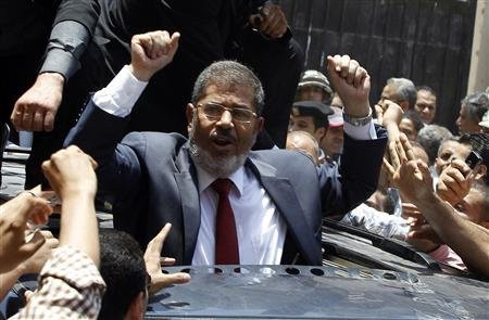 Tổng thống đắc cử Ai Cập Mohamed Morsy vẫy chào người ủng hộ Presidential candidate Mohamed Morsy of the Muslim Brotherhood waves to his supporters after casting his vote at a polling station in a school in Al-Sharqya, 60 km (37 miles) northeast of Cairo in this June 16, 2012 file photo.