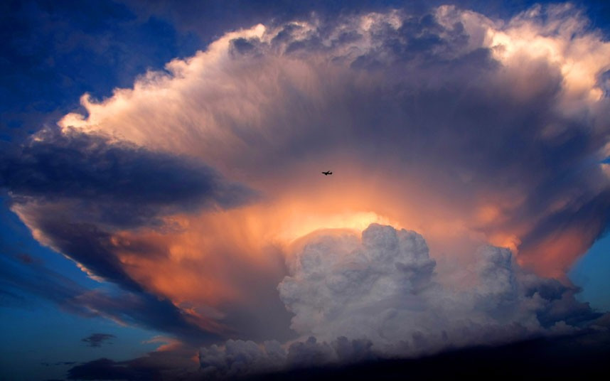 Những hình ảnh ấn tượng trong tuần ảnh 2 A jet plane flies past a mushroom-like cumulonimbus storm cloud over Beijing, China