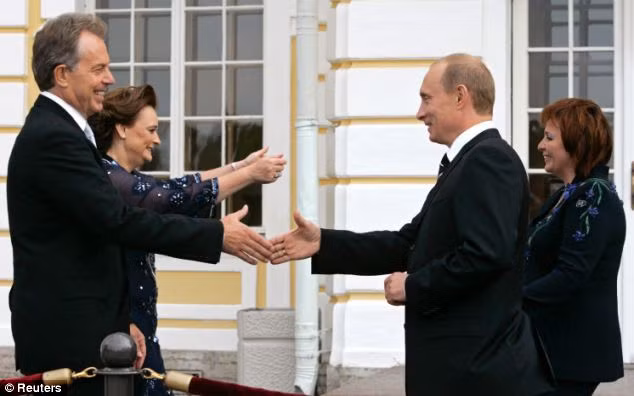 Russian President Vladimir Putin greets British Prime Minister Tony Blair as his wife Lyudmila greets Blair