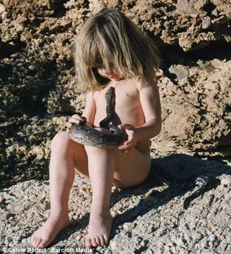 No fear: The young child cradles a rock python snake and plays with her favourite elephant Read more: http://www.dailymail.co.uk/news/article-2337418/The-REAL-Mowgli-Incredible-images-little-girl-spent-years-life-growing-African-bush.html#ixzz2Vakrqyqs Follow us: @MailOnline on Twitter | DailyMail on Facebook