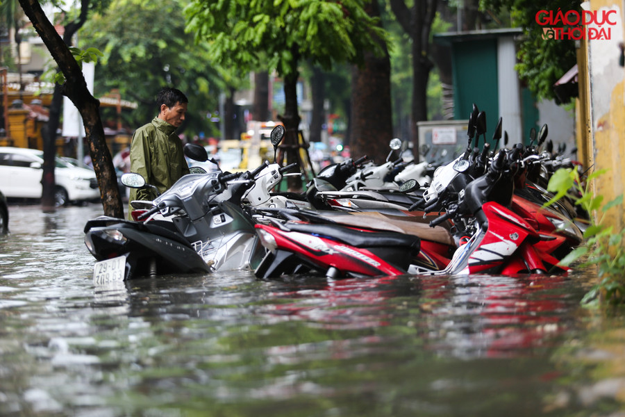 Trên tuyến phố Phan Bội Châu nhiều bãi đỗ xe nước ngập nửa xe máy cho dù xe đang để trên vỉa hè