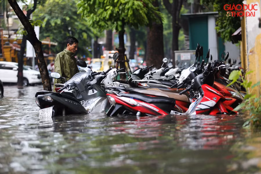 Trên tuyến phố Phan Bội Châu nhiều bãi đỗ xe nước ngập nửa xe máy cho dù xe đang để trên vỉa hè