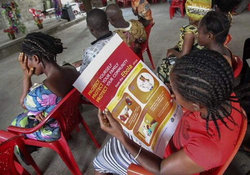 Một người phụ nữ Liberia đang đọc thông tin trên tấm poster về cách phòng chống dịch bệnh Ebola. (Ảnh: European Pressphoto Agency)