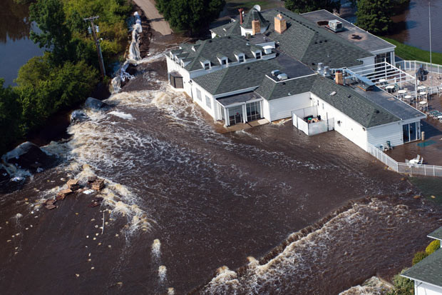 Những hình ảnh ấn tượng trong tuần ảnh 7 Flood waters begin to pour through a breached levee and flood the Minot Country Club in Minot, North Dakota