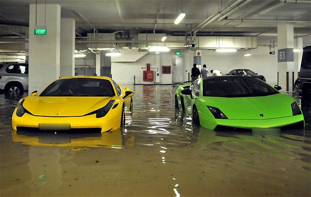 Millions of pounds worth of supercars have been damaged after a flash flood swept through an underground car park of one of the world’s most exclusive apartment blocks. The St Regis Apartments, on Singapore’s coastline, plays home to a number of £10-million flats with the wealthy residents owning a mixture of sparkling motors. But the multi-millionaires were counting the cost after their cars became submerged when a warning system failed to alert the apartment management of the flooding. As a result a dozen supercars suffered damage - including a yellow Ferrari 458 Italia and a green Lamborghini Gallardo.