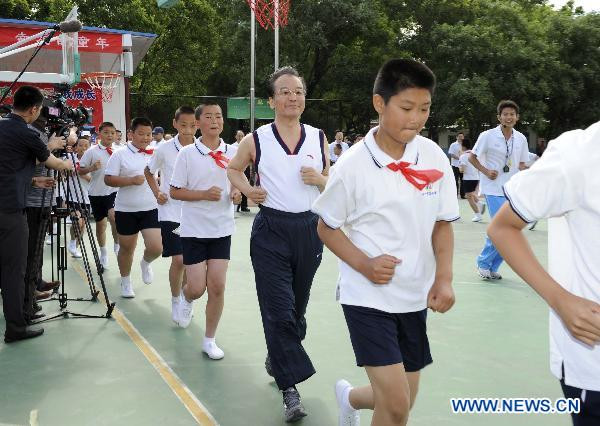Chinese Premier Wen Jiabao joins a training in the Shibalidian Primary School in Beijing’s Chaoyang District, May 31, 2011. Wen took part in a 40-minute basketball training session here with a group of pupils Tuesday in Beijing, encouraging Chinese children to keep themselves healthy by participating in sports and other physical activities. 